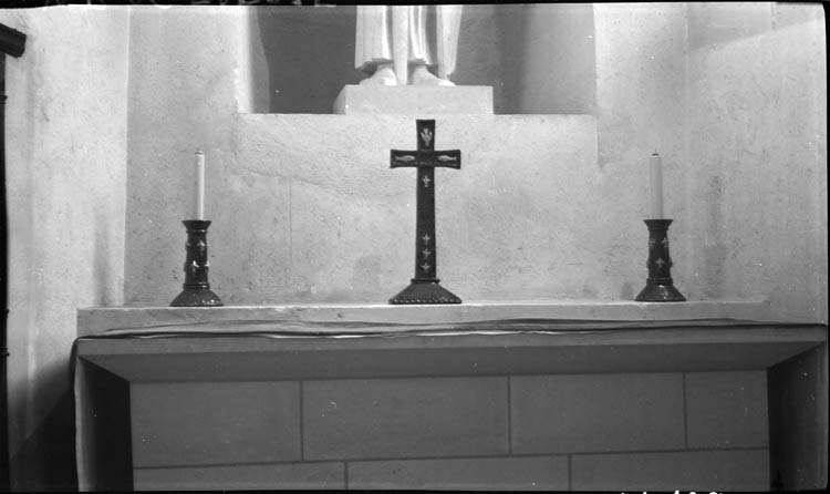 Porte-cierge et croix sur l’autel au pied de la statue de saint Louis