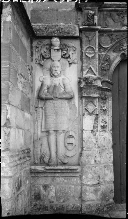 Une des deux statues en bas-relief encadrant la porte (gauche)