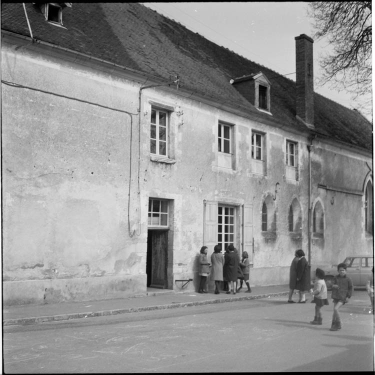 Façade sur rue ; groupes sur le trottoir