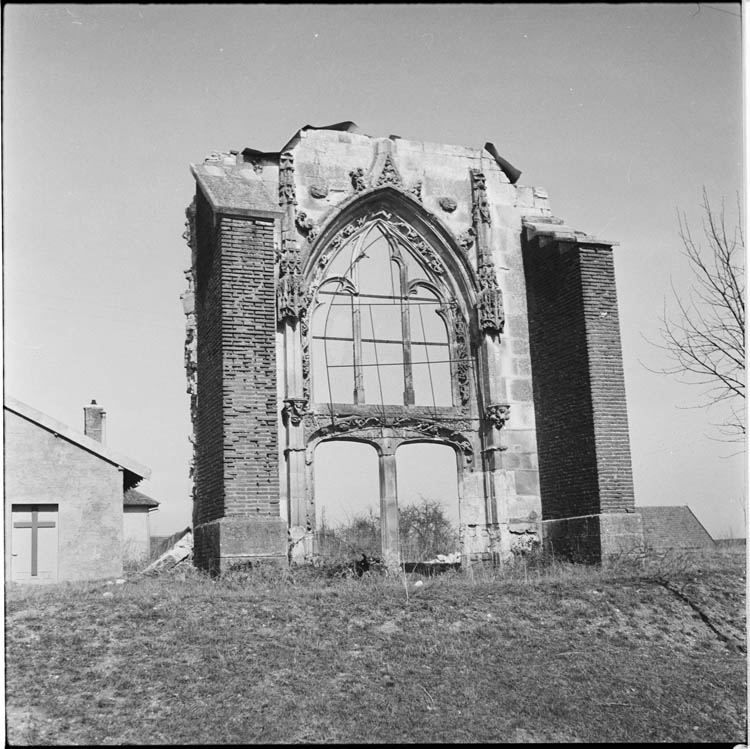 Vestige : pan de mur conservant la structure d’une porte géminée surmontée d’une baie, tenu par deux contreforts