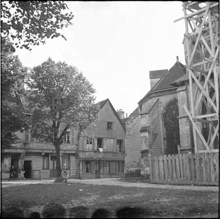 Vue partielle de la façade échafaudée et maisons environnantes