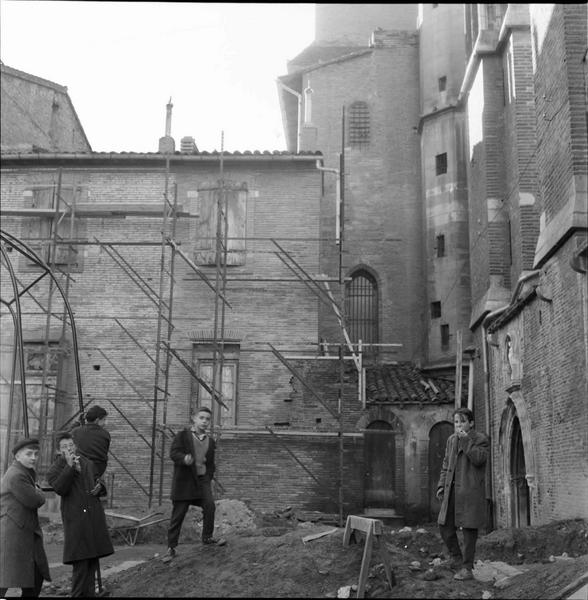 Façade latérale et bâtiment attenant échafaudé ; enfants sur le chantier