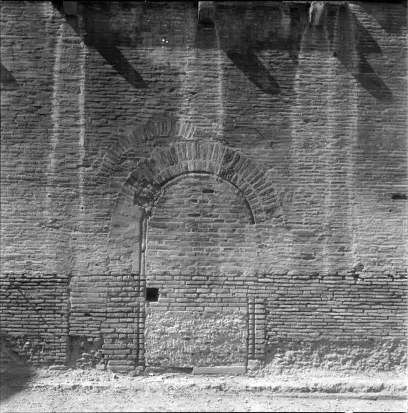 Vue partielle d'un mur : traces d'arcatures, baie obstruée