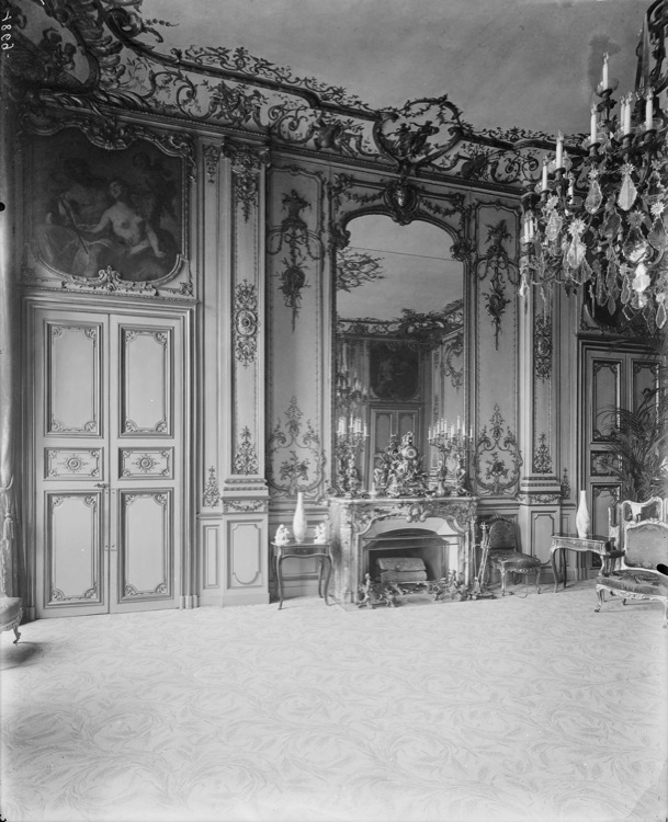 Grand salon de réception : porte, tableau encastré en dessus-de-porte, boiseries et glace côté cheminée