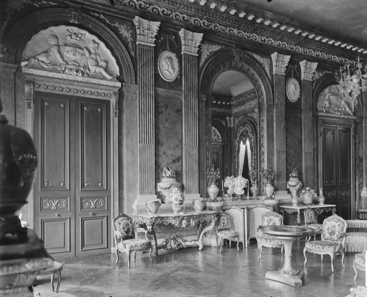 Grand salon : portes ornementées, pilastres cannelés et grande glace