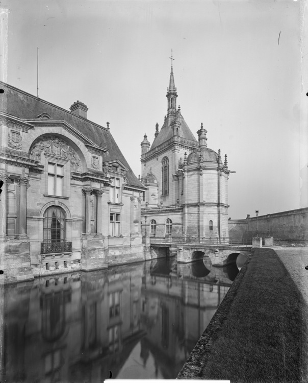 Pavillon d’angle et abside de la chapelle se reflétant dans les douves