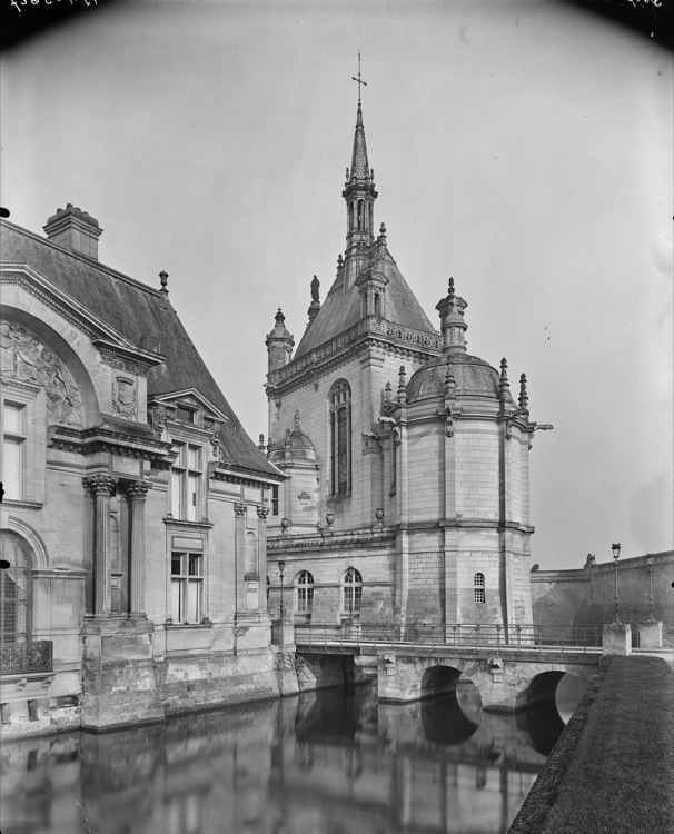 Pavillon d’angle et abside de la chapelle se reflétant dans les douves