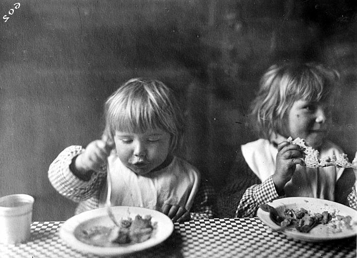 Intérieur, dîner des enfants : deux fillettes mangeant