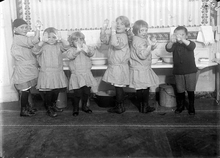 Dortoir des enfants, intérieur : la salle de bains, les enfants montrent leurs mains propres