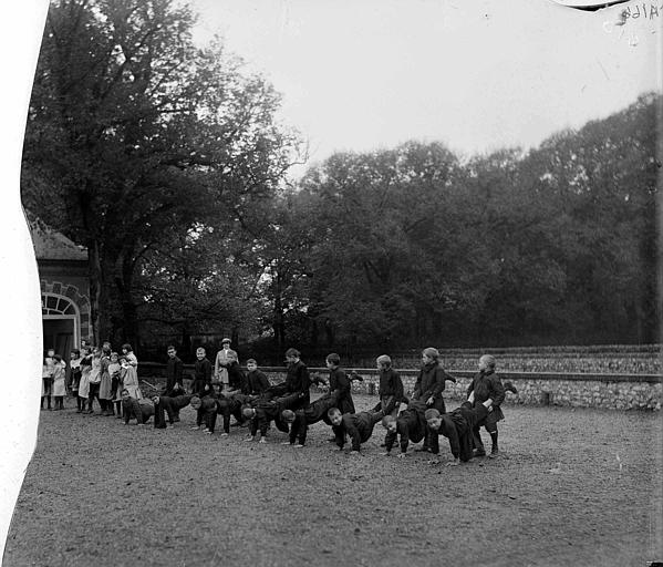 Jeux à la colonie d'enfants : groupe d'enfants faisant la brouette