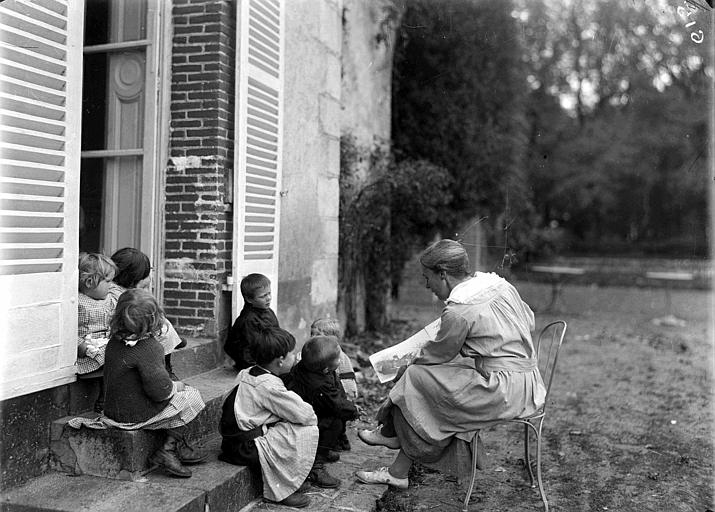 Extérieur : éducatrice lisant un conte de fées à des petits enfants