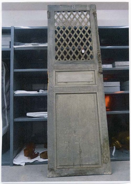 porte d'une cage à poule  (porte de prison, cellule individuelle grillagée)