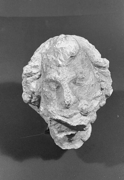 Statue en pierre de Romain, fragment : tête d'homme (très abîmée), de face