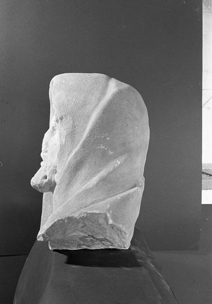 Statue en marbre blanc, fragment : tête de vieillard portant un capuchon, profil gauche