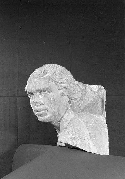 Statue en pierre de Romain, fragment : tête de bourreau imberbe provenant du portail nord de la façade ouest, de trois quarts gauche