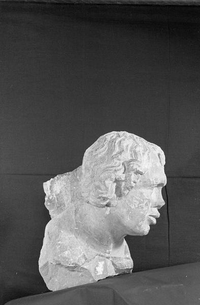 Statue en pierre de Romain, fragment : tête de bourreau imberbe provenant du portail nord de la façade ouest, de trois quarts droit