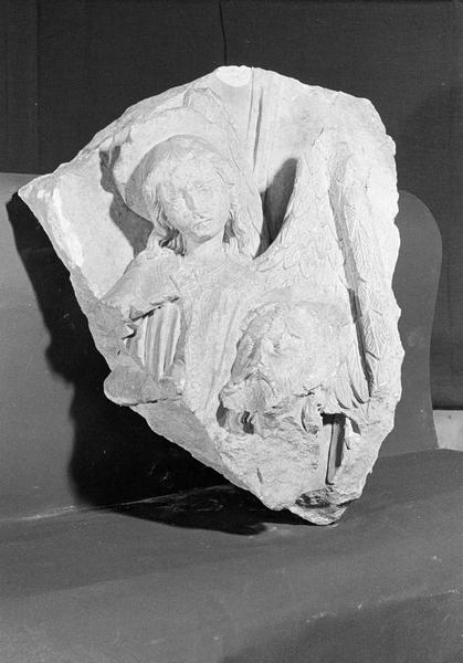 Haut-relief en pierre de Courville, fragment : ange et tête d'homme nimbée, de face