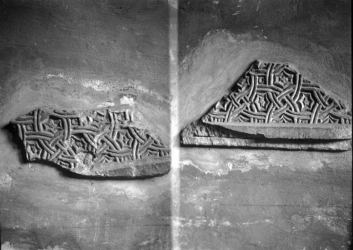 Crypte : Deux fragments sculptés en bas-relief plaqués contre le mur de sortie droit