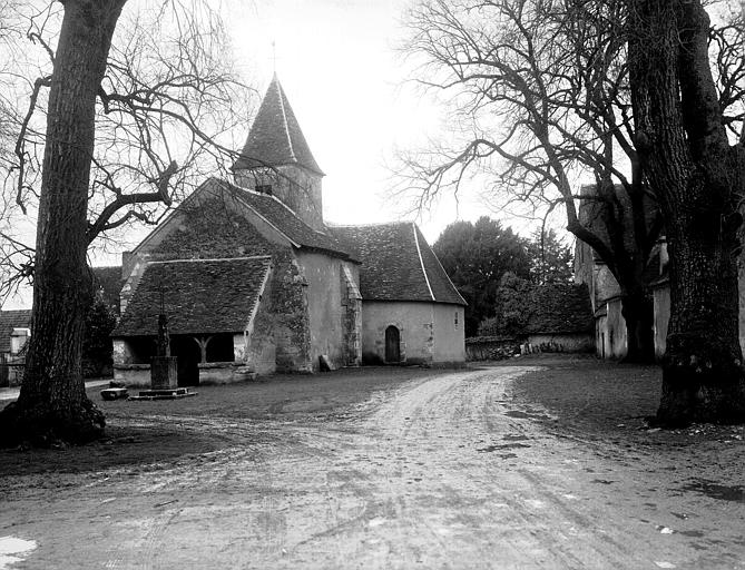 Vue de la place du village avec l'église à droite de l'entrée du château