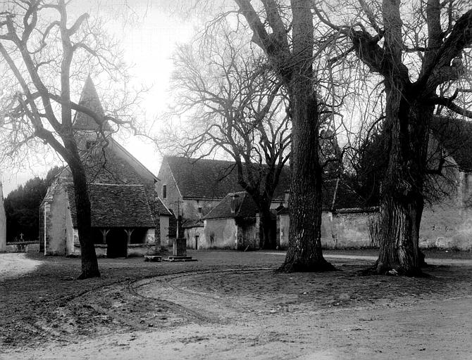 Vue de la place du village avec l'église à droite de l'entrée du château