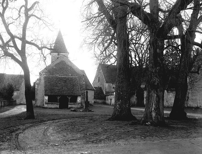 Vue de la place du village avec l'église à droite de l'entrée du château