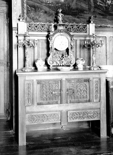 Bahut crédence en bois du 15e siècle et garniture de cheminée constituée d'une pendule Louis XIV et de candélabres Louis XV, situés dans le Grand Salon
