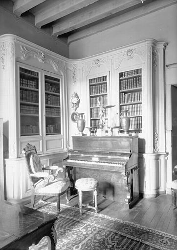 Bibliothèque d'angle en bois sculpté et peint Louis XV, située dans le Petit Salon