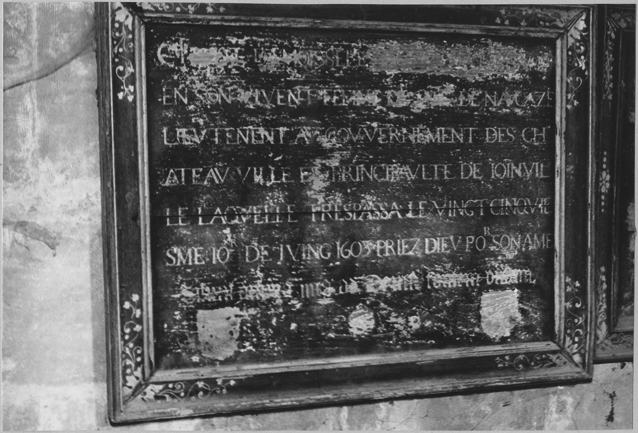 plaque funéraire et son cadre (épitaphe), inscription dont la première ligne est illisible. 