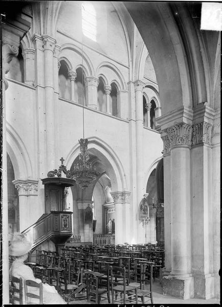 Intérieur : nef avec chaire à prêcher et femme assise, depuis le bas-côté sud