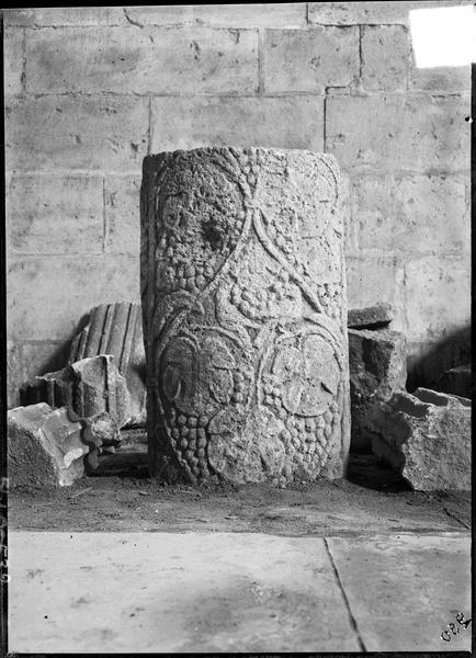 Intérieur : fragment d'un pilier en pierre sculpté de feuilles de vigne