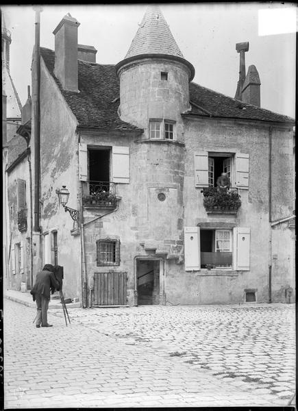 Façade avec tourelle sur rue et photographe avec chambre sur trépied