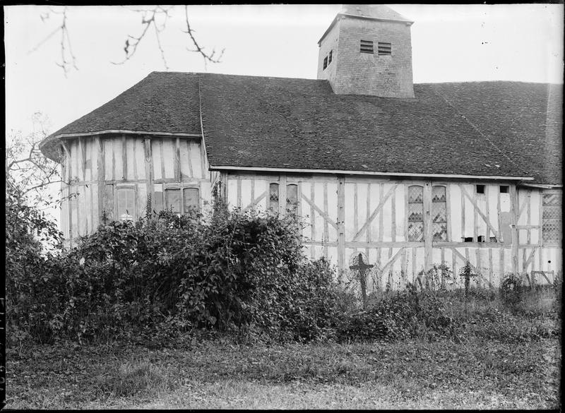 Façade nord à pans de bois, vue partielle et cimetière au premier plan