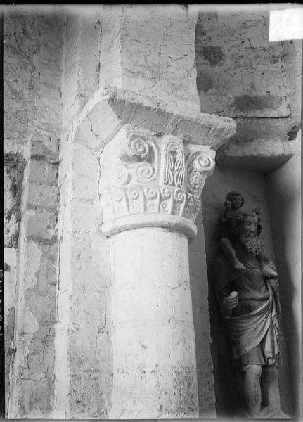 Intérieur : chapiteau sculpté et statue de saint Christophe dans une niche