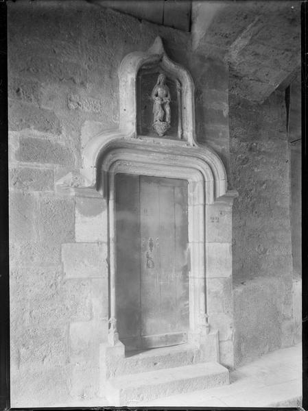 Porte avec linteau en accolade, surmontée d'une statue polychrome de sainte Anne enseignant à la Vierge