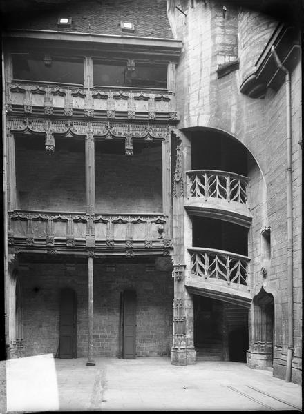 Façade sur cour intérieure avec galeries en bois et escalier d'angle à rampe sculptée