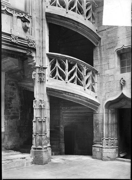 Partie inférieure de l'escalier d'angle à rampe sculptée, vue de la cour intérieure