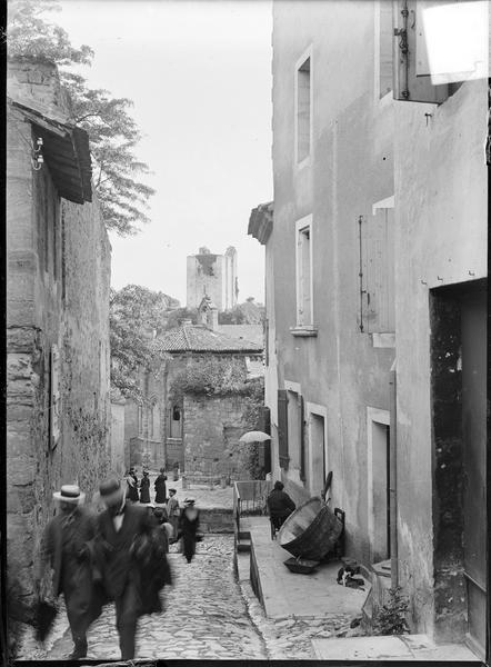 Ensemble nord-est pris d'une ruelle animée de la ville avec la chapelle de la Trinité en contrebas