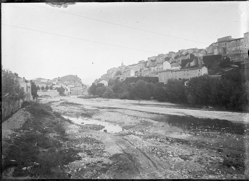 Vue d'ensemble de la ville depuis les rives de l'Ouvèze avec le pont au loin