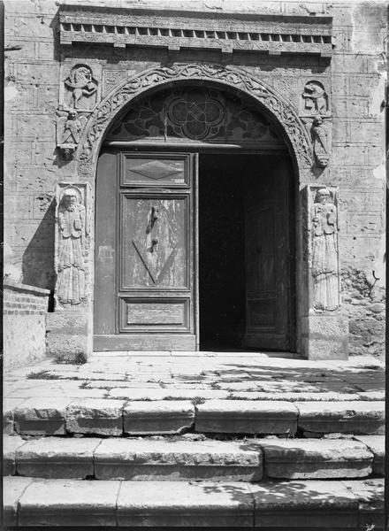 Porte du logis abbatial entourée des symboles des quatre évangélistes et des statues de saint Pierre et saint Paul au niveau des piédroits