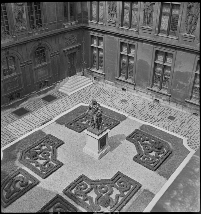 Vue plongeante sur un parterre et la statue de Louis XIV