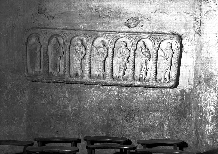 Devant de sarcophage en pierre encastré sous la tribune : sept  personnages sous arcature