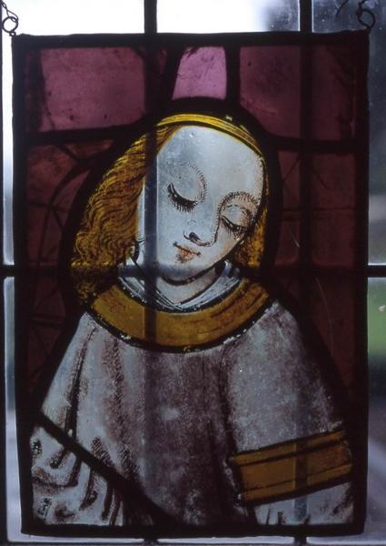 verrière : Personnage à coiffure dorée sur fond mauve (ange ?) - © Monuments historiques