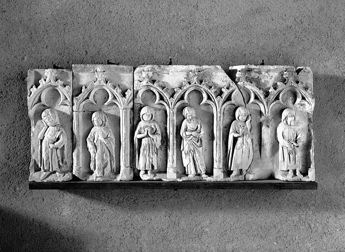 Soubassement de tombeau (supposé) en pierre : personnages debouts sous arcature trilobée