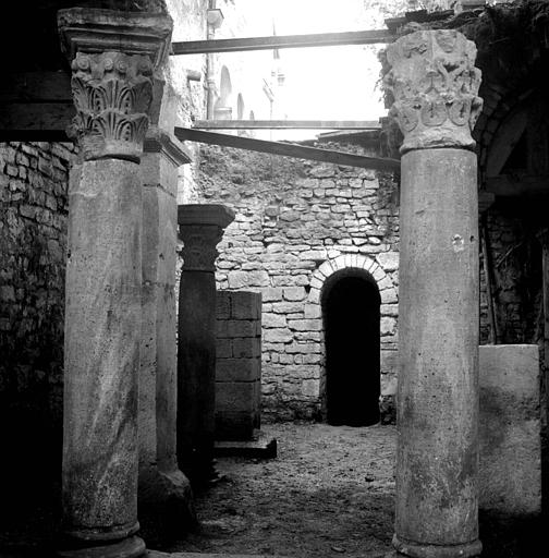 Fouilles de la crypte : travées droites vers l'ouest et colonnes de l'hexagone. Au fond, la baie communique avec la rotonde centrale. Chapiteaux romans : celui du sud était avant 1959 au musée lapidaire