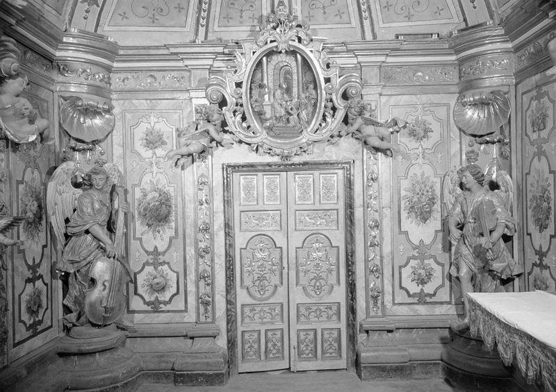 Intérieur, camaril : mur nord, médaillon sculpté représentant la Présentation de Marie au Temple surmontant la porte encadrée de deux statues d'anges musiciens