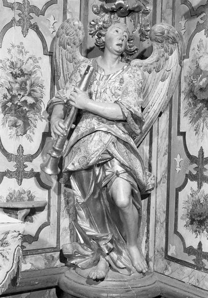 Décor intérieur du camaril : statue d'ange musicien jouant d'un instrument à vent, de face