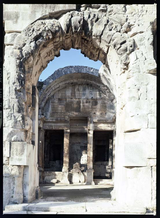 Intérieur en ruine vu au travers d'une arcade