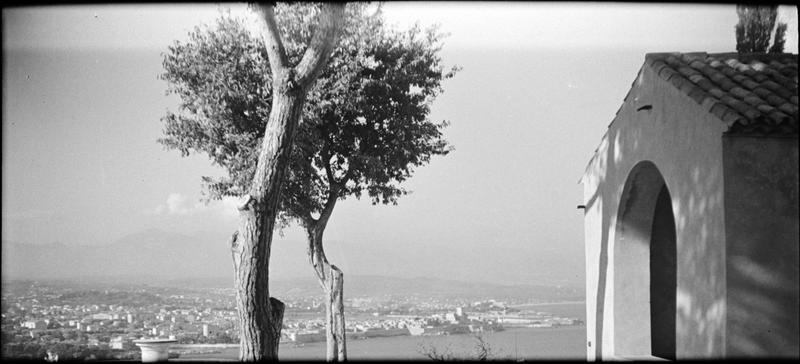 Porche ouest, vu en perspective côté sud, et vue sur Antibes en arrière-plan. Vue panoramique