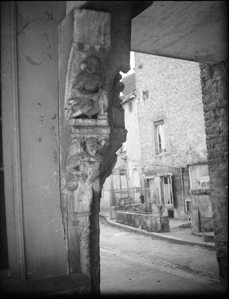 Poteau cornier orné de sculptures représentant un artisan surmontant un ange