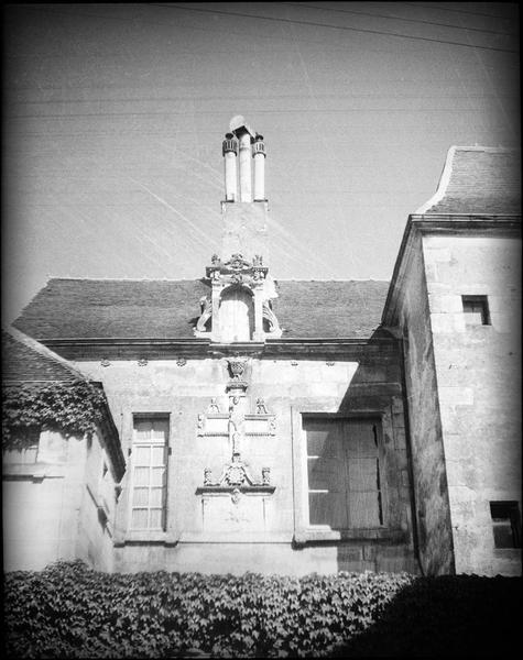 Façade sur rue, fenêtres à meneaux, lucarne des combles et cheminée